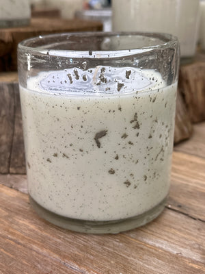 Soy candle in foil flecked glass jar on a wooden surface