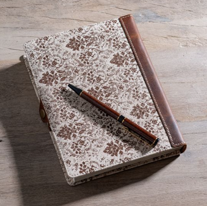 Floral-patterned notebook with a pen on a wooden surface