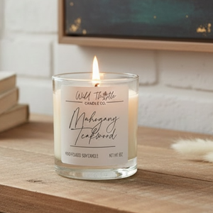 Candle with a label on a wooden surface, with a blurred background