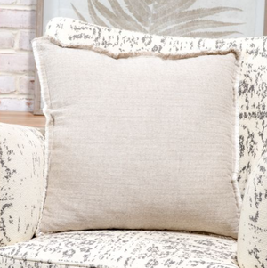 20-inch beige cotton throw pillow with soft textured fabric on a couch